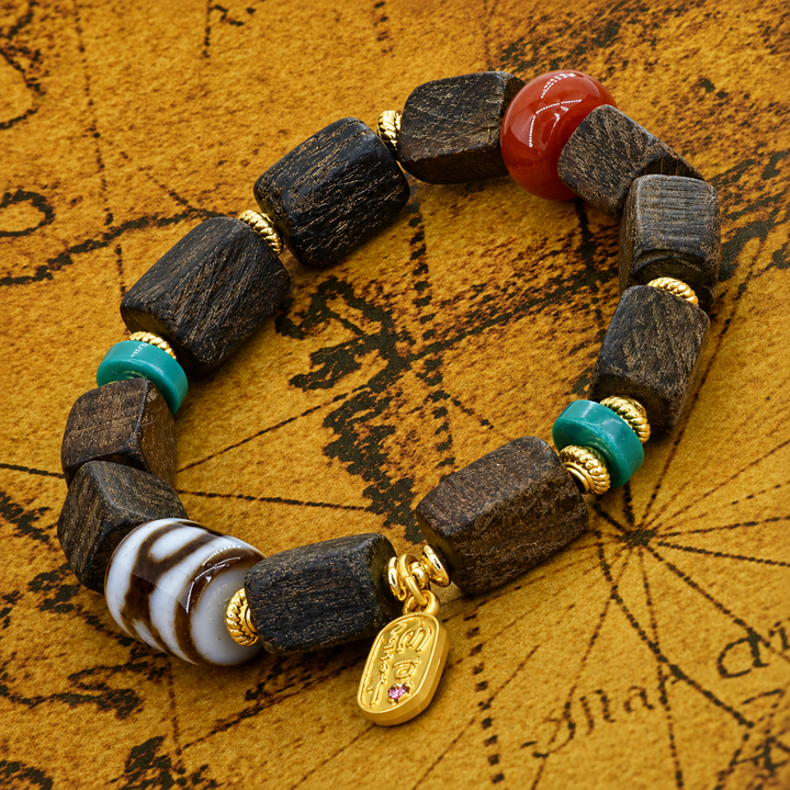 Handcrafted Himalayan Dark Wood Block Bead Bracelet with Patterned Dzi Stone, Turquoise Accents, Red Agate, and Gold-Tone Mantra Charm
