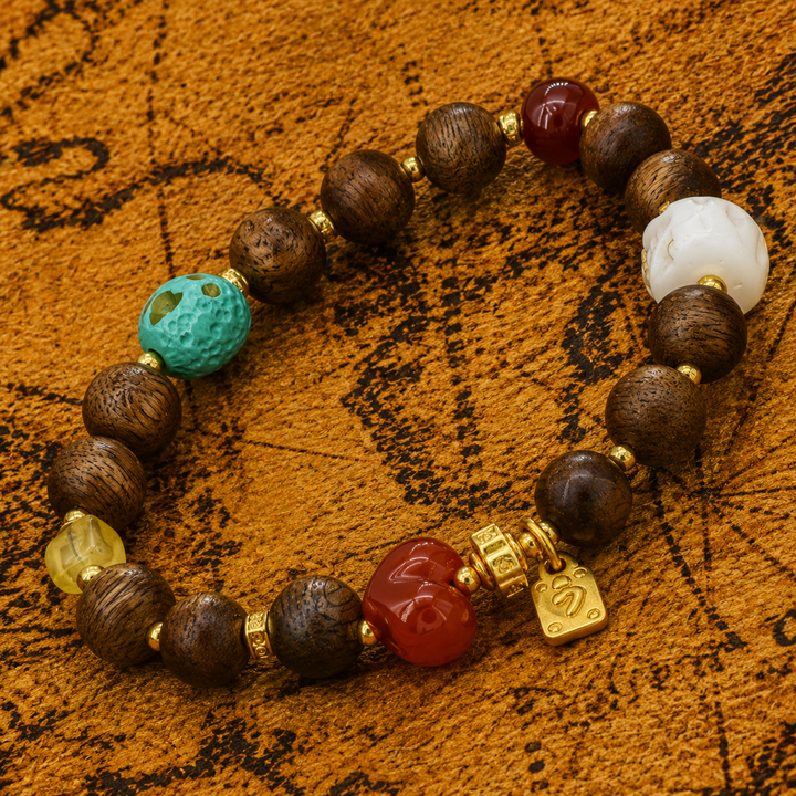 Himalayan Sandalwood and Carved Bone Skull Bead Bracelet Featuring Heart-Shaped Carnelian, Turquoise, and Gold Fortune Charm