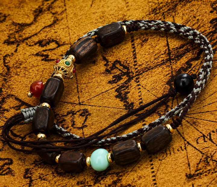 Adjustable Braided Cord Wrap Bracelet Featuring Dark Wooden Barrel Beads, Turquoise Accent, Red Carnelian, and Gold-Plated Prayer Wheel Charm